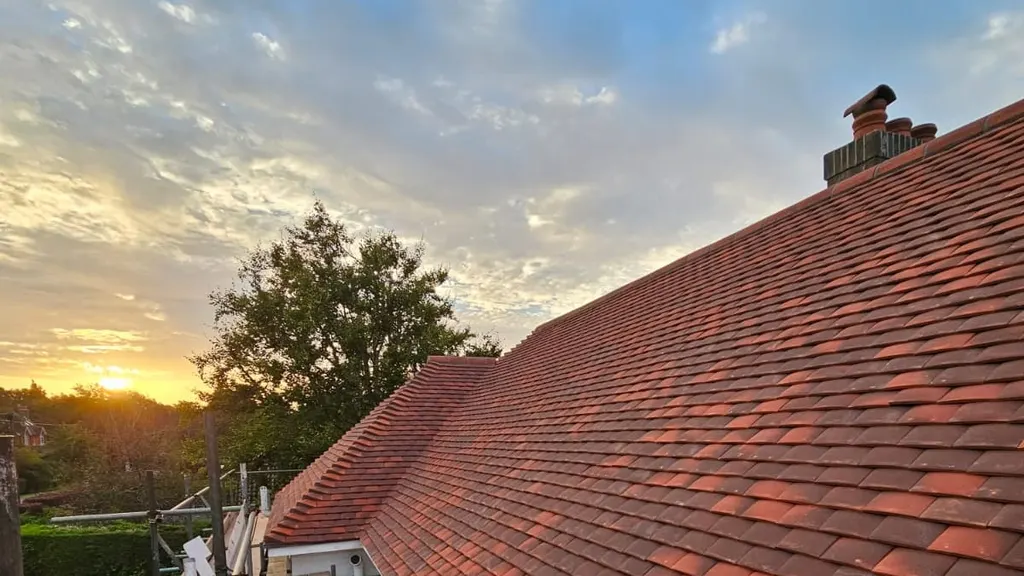 A completed clay tiled re-roof by Masters Roofing photographed at sunset