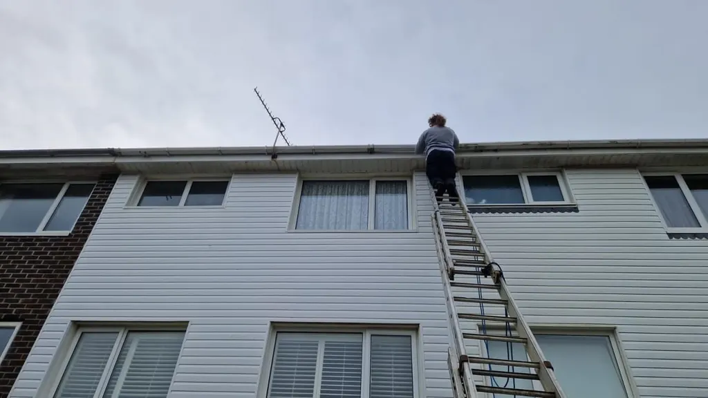 A ladder run up to the roof of a three-storey block during an out-of-hours call-out