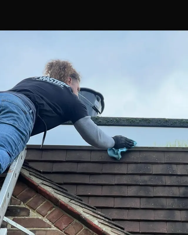 A Masters Roofing roofer working along the ridge of a bungalow during a call-out