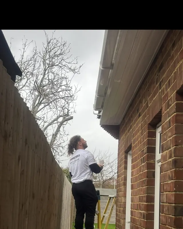 A Masters Roofing fitter working along the eaves fitting a new fascia board