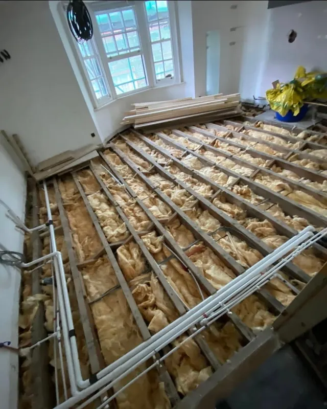 The same building during the strip-out, with the floorboards lifted and the joists exposed