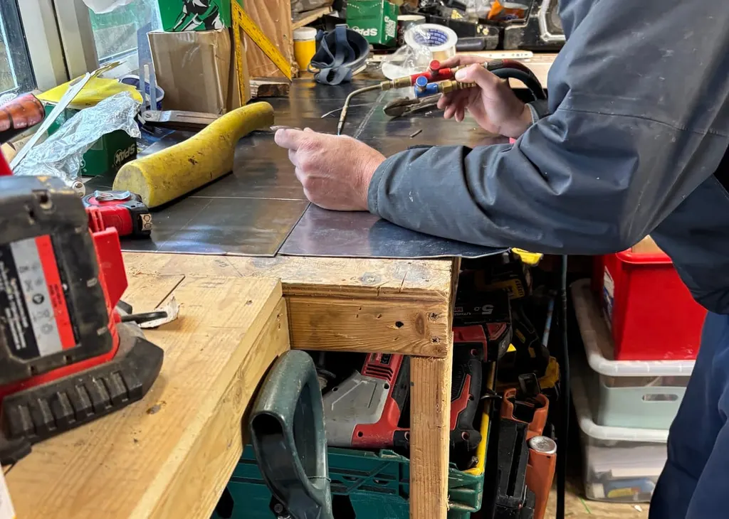 A sheet of lead being marked and bossed on the bench before it goes up on the roof