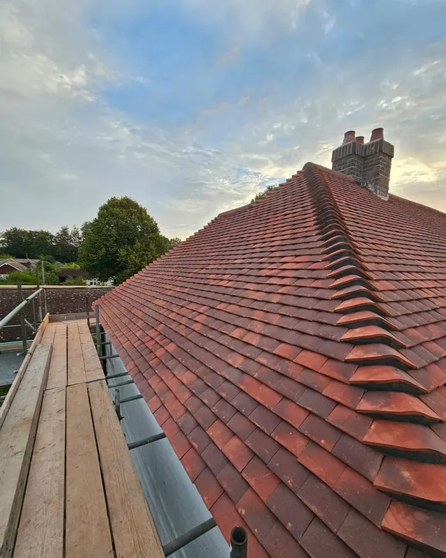 A completed hip in handmade clay plain tiles with a bonnet hip and new ridge