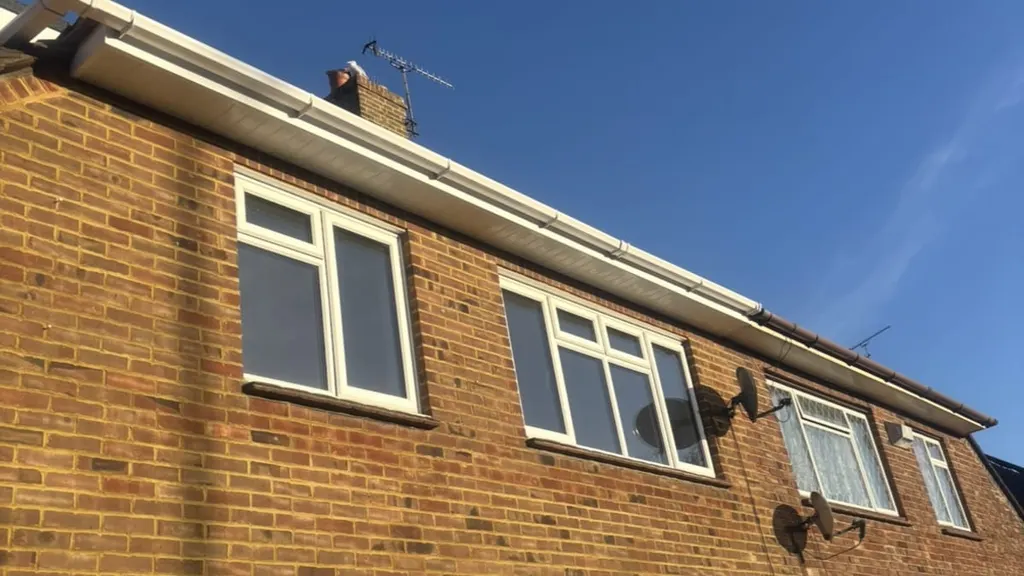 The front elevation of a semi-detached house with new white fascias, soffits and guttering by Masters Roofing