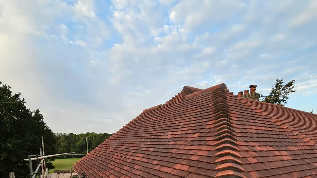 A completed clay tiled re-roof by Masters Roofing seen across the scaffold