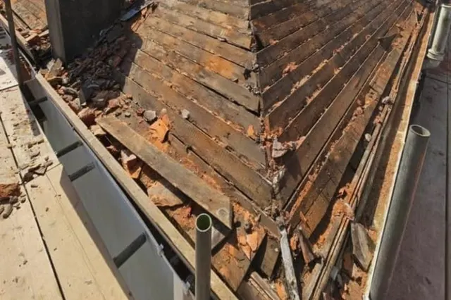 The same roof earlier in the job, with the old covering stripped off and the rafters and battens exposed