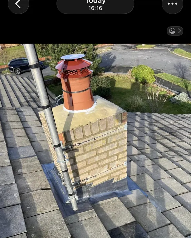 New lead flashing dressed into a repointed chimney stack, with a fresh lead apron across the front of the stack