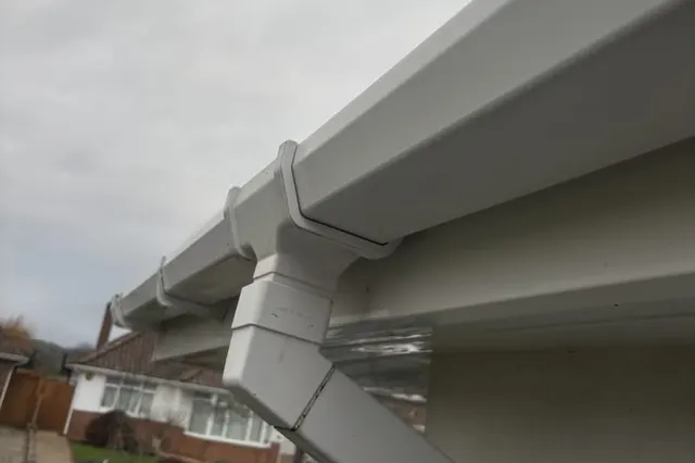 Newly fitted white UPVC fascias, vented soffits and guttering running along the eaves of a bungalow