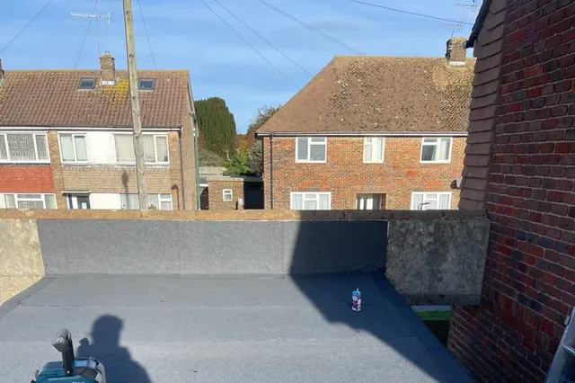A completed torch-on felt flat roof by Masters Roofing, laid in bonded layers with a new mineral cap sheet and edge trim