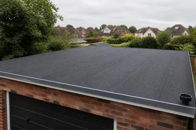 Completed torch-on felt flat roof system with new drip edge and outlet on a garage roof in Worthing